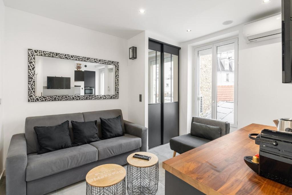 un salon avec un canapé et une table dans l'établissement Studio Climatisé - Ultra Lumineux - Proche Paris, à Saint-Maurice