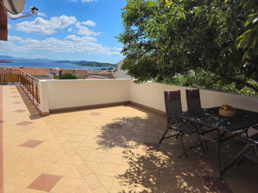a patio with a table and chairs on a balcony at Apartmani Patača in Vodice