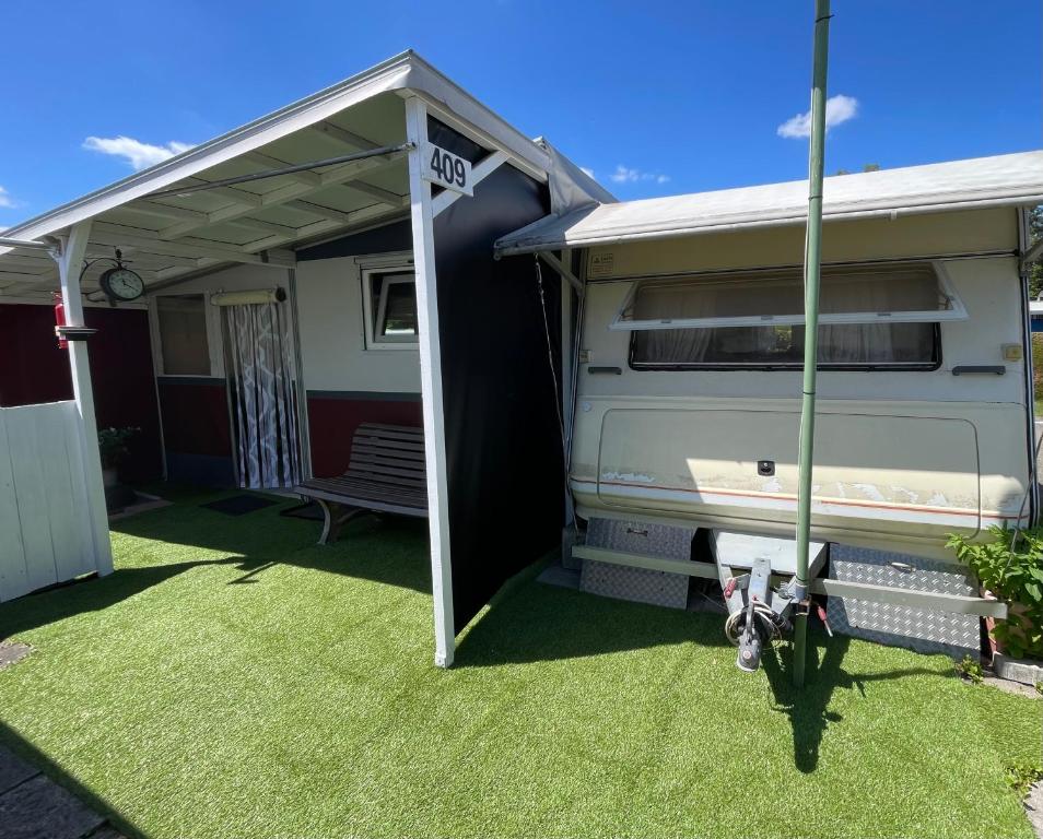 awning over an rv with a grass yard at Campingplatz Wohnwagen mit Vorzelt in Affing