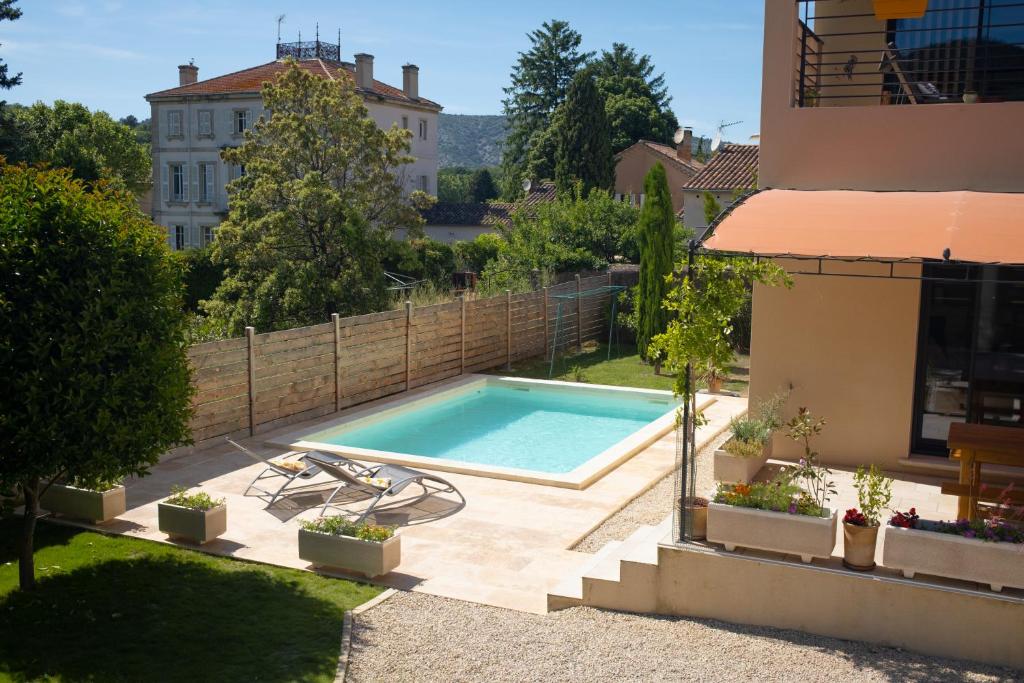 - une piscine dans une cour à côté d'un bâtiment dans l'établissement L'Abri de Malaucène - Gîte Cycliste, à Malaucène