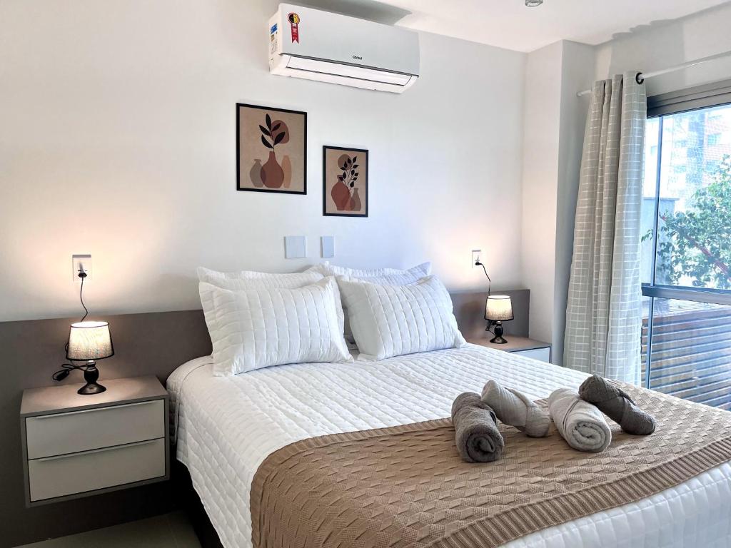 a bedroom with a bed with towels on it at Suíte com jardim e piscina na Barra Olímpica RJ in Rio de Janeiro