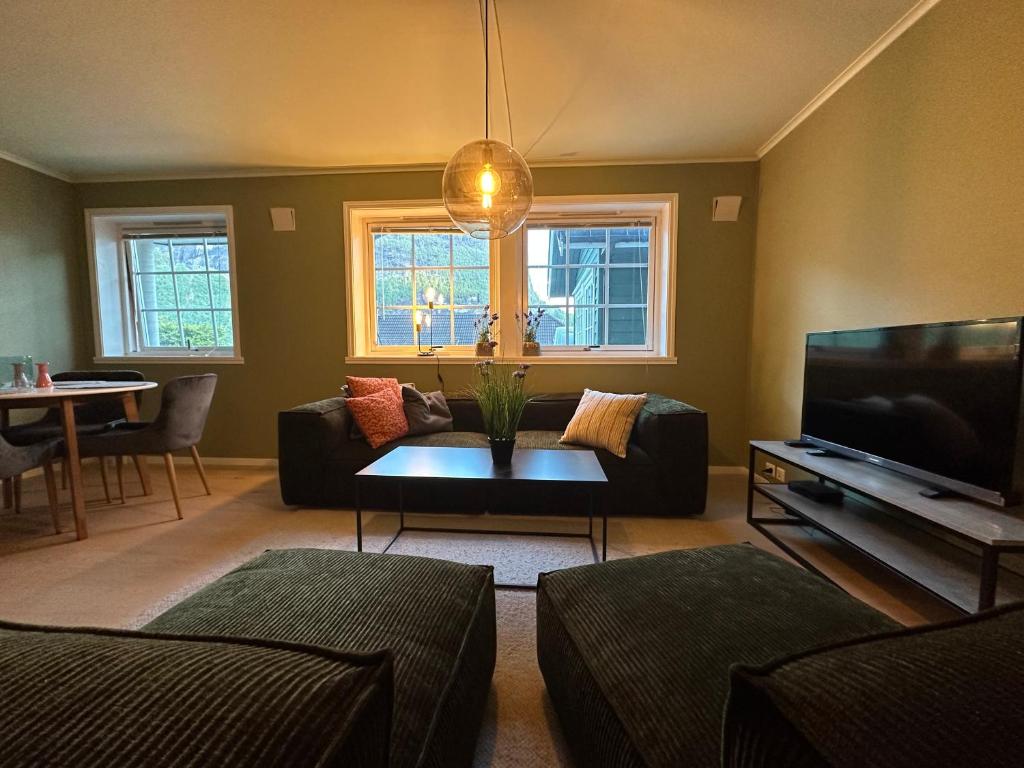a living room with a couch and a tv at Leilighet nært sentrum in Stryn