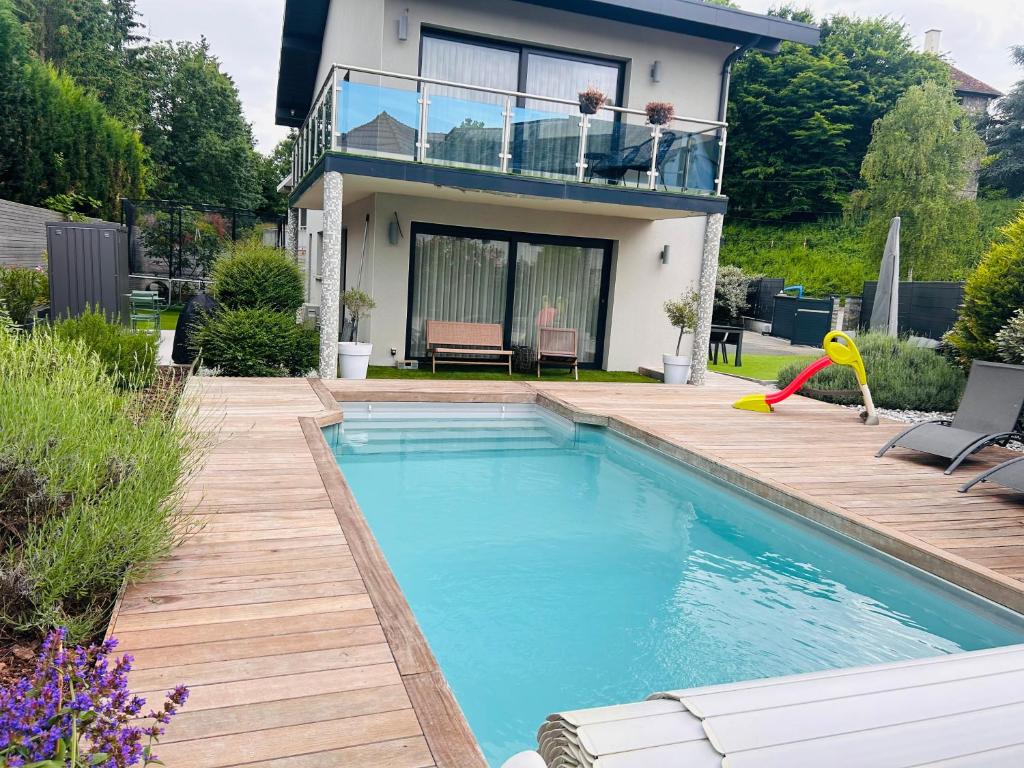 a swimming pool in front of a house at Maison T5 avec piscine T5chambres Annecy in Annecy