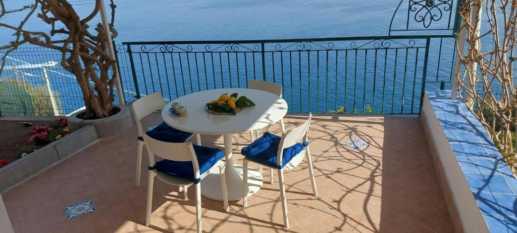 a table and chairs on a balcony with the ocean at Casa Pappalardo in Ravello