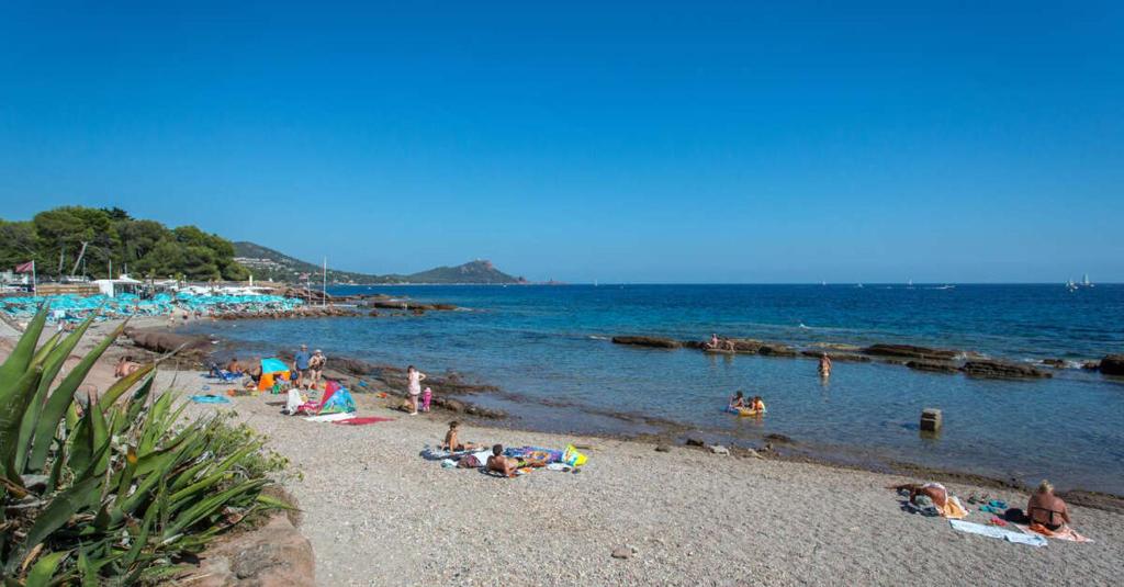 un groupe de personnes sur une plage près de l'eau dans l'établissement 2 pièces terrasse proche mer, à Saint-Raphaël