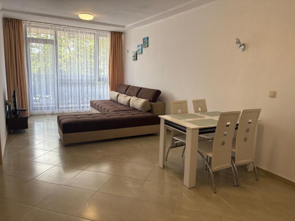 a living room with a couch and a table and chairs at Апартаменти Меден Рид in Sozopol