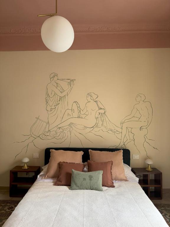 a bedroom with a bed with a painting on the wall at Academia Apulian Suites - Marsia's Apartment in Mola di Bari
