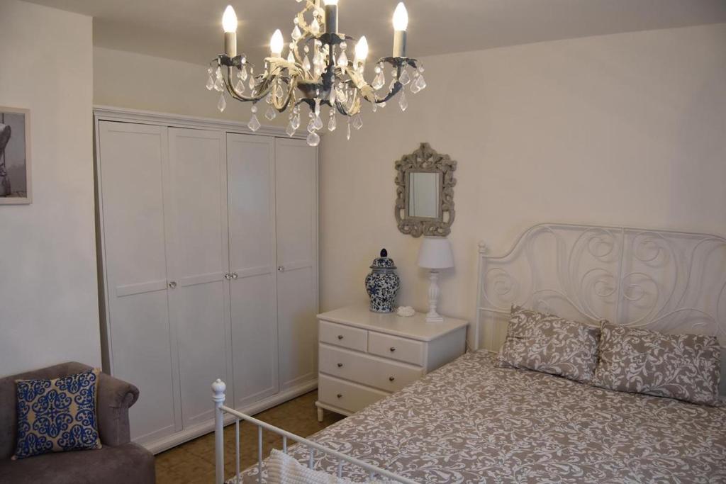 een slaapkamer met een bed en een kroonluchter bij Family House Stara Novalja in Stara Novalja