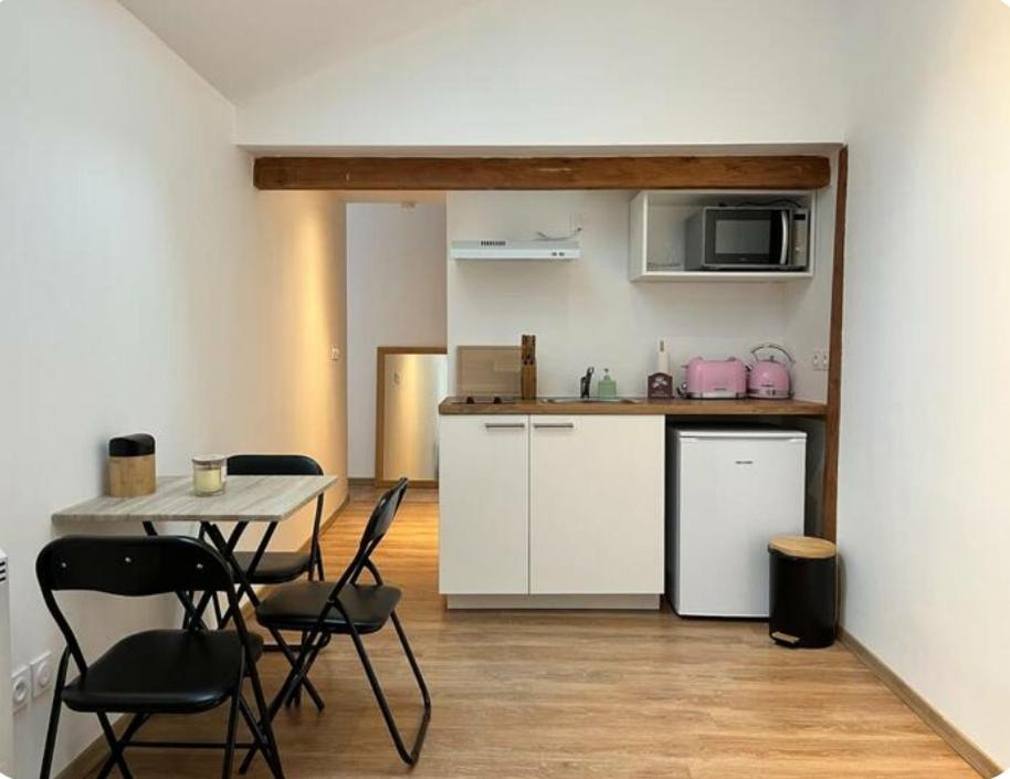 une cuisine avec une table et des chaises dans une pièce dans l'établissement Echarvines, à Talloires