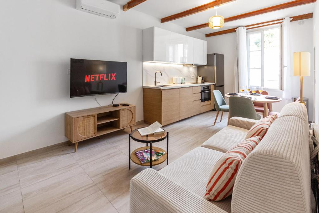 un salon avec un canapé et une télévision et une cuisine dans l'établissement L'Aubernon - Hypercentre - Old Antibes - AC - Beach, à Antibes