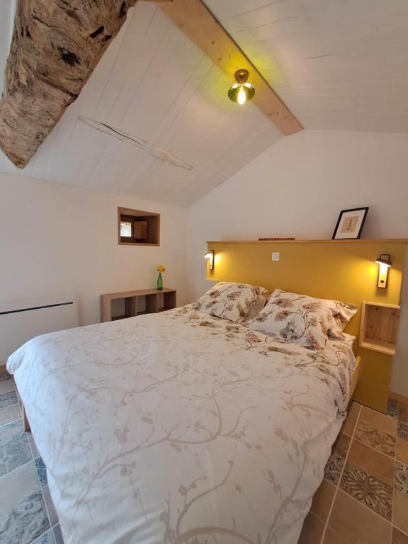 une chambre avec un grand lit dans une pièce dans l'établissement studio voulmentin, à Saint-Clémentin