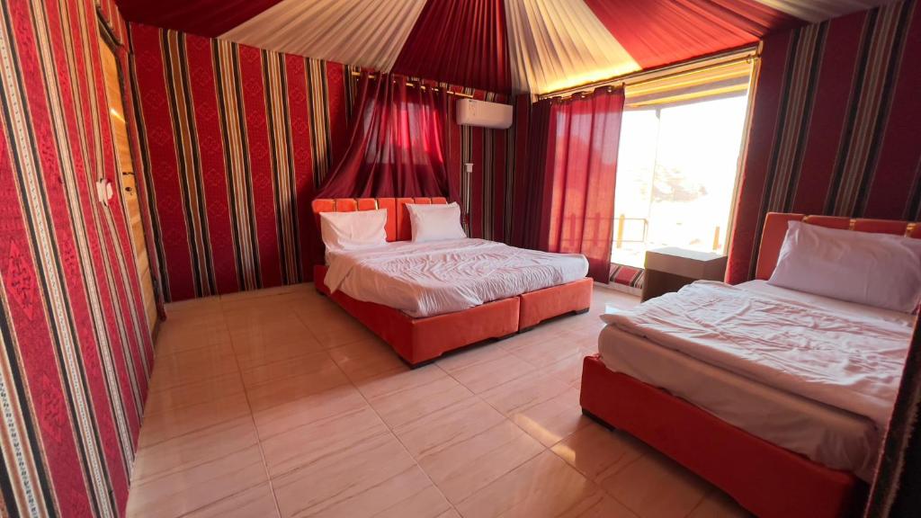 a hotel room with two beds and a window at Wadi Rum Sand moon Camp &Tour in Wadi Rum