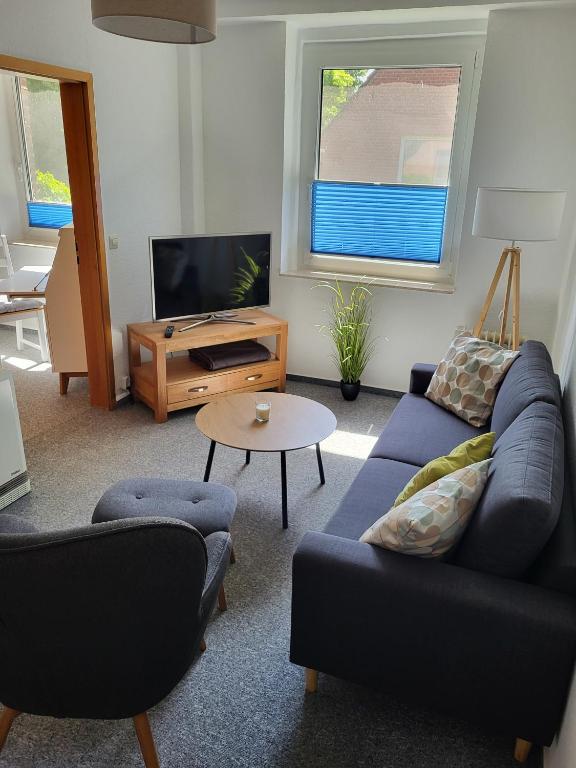 a living room with a blue couch and a tv at Ferienwohnung Kormoran in Kargow