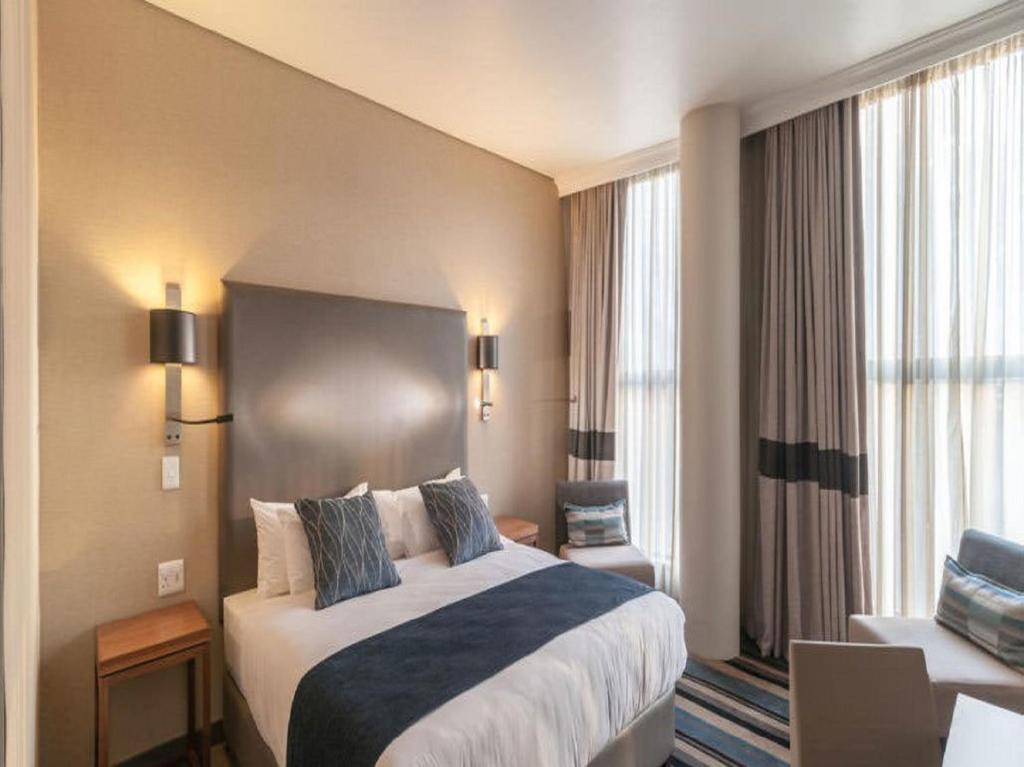 a hotel room with a bed and a large window at Hotel Goodwill Stay Near Delhi Airport in New Delhi