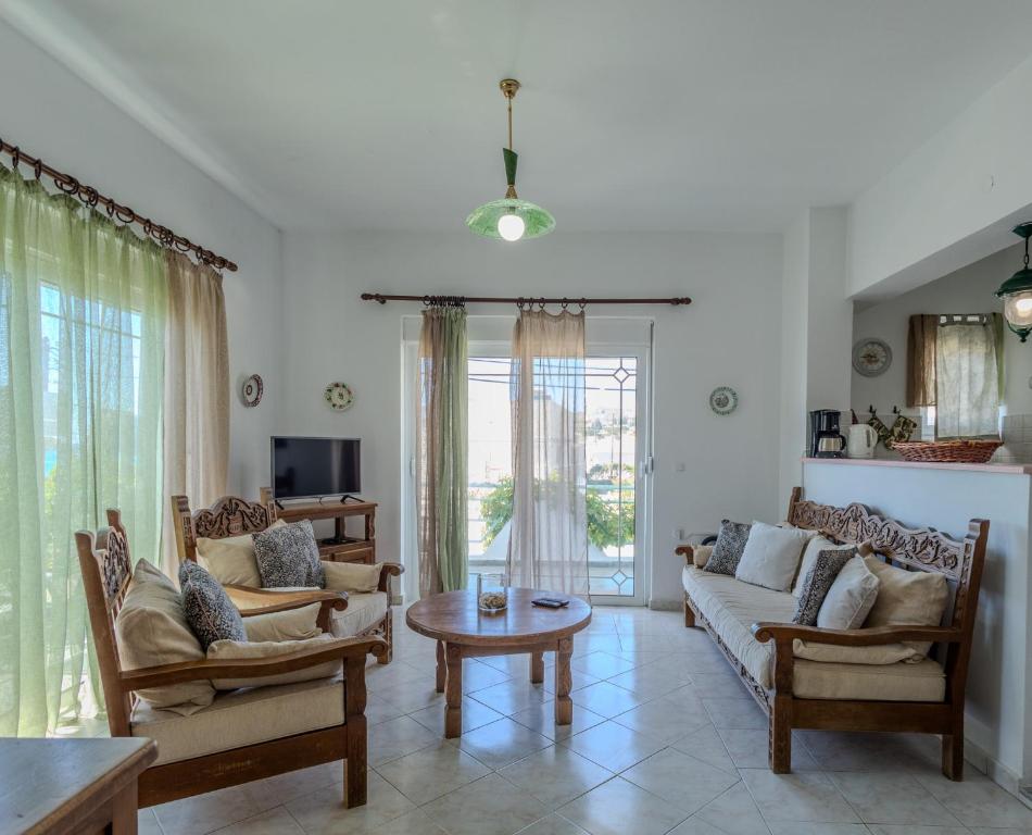 a living room with a couch and chairs and a table at STEGNA REA Seaside Apartment in Archangelos