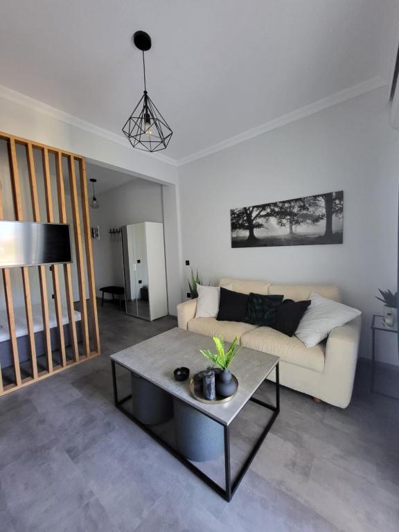 uma sala de estar com um sofá e uma mesa em The cosy nest em Asprovalta