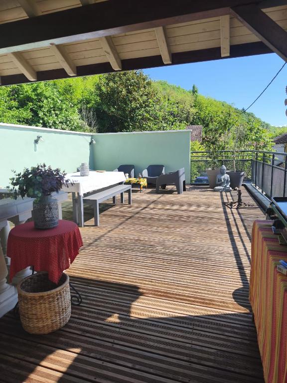 une terrasse en bois avec une table et des chaises dessus dans l'établissement Le Kalora, Maison avec terrasse entre lacs et montagnes, à Serrières-en-Chautagne