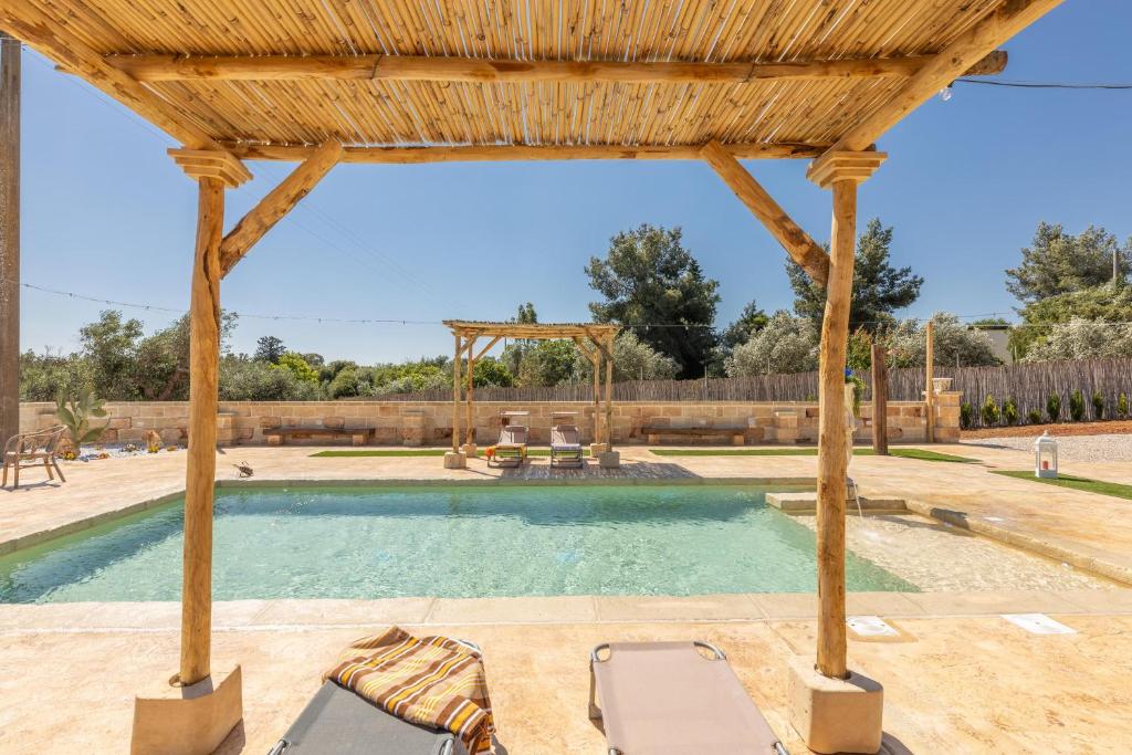 une piscine extérieure avec une pergola en bois dans l'établissement Villa Galatea, à Galatone