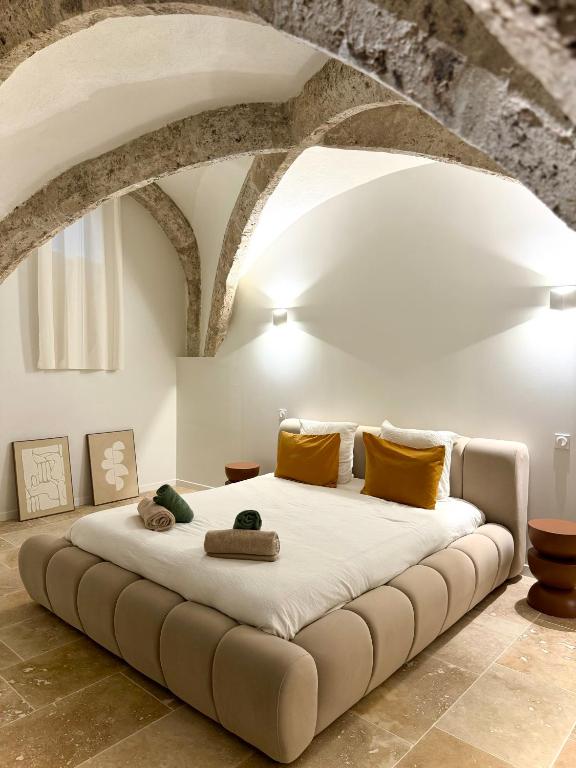 - une chambre avec un grand lit blanc et des oreillers jaunes dans l'établissement Les Voûtes de Blois, à Blois