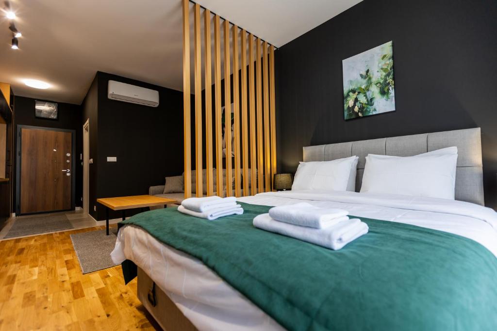 a bedroom with a large bed with towels on it at Field Apartments and SPA Kolasin in Kolašin