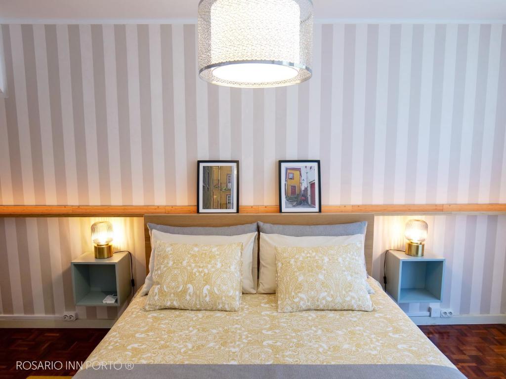a bedroom with a bed with two pillows and two lamps at rosario inn porto in Porto