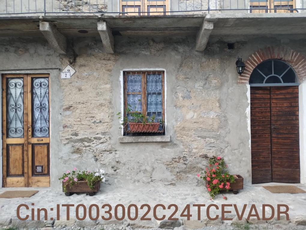 a stone house with a window and a door at La casa nel verde in Ameno