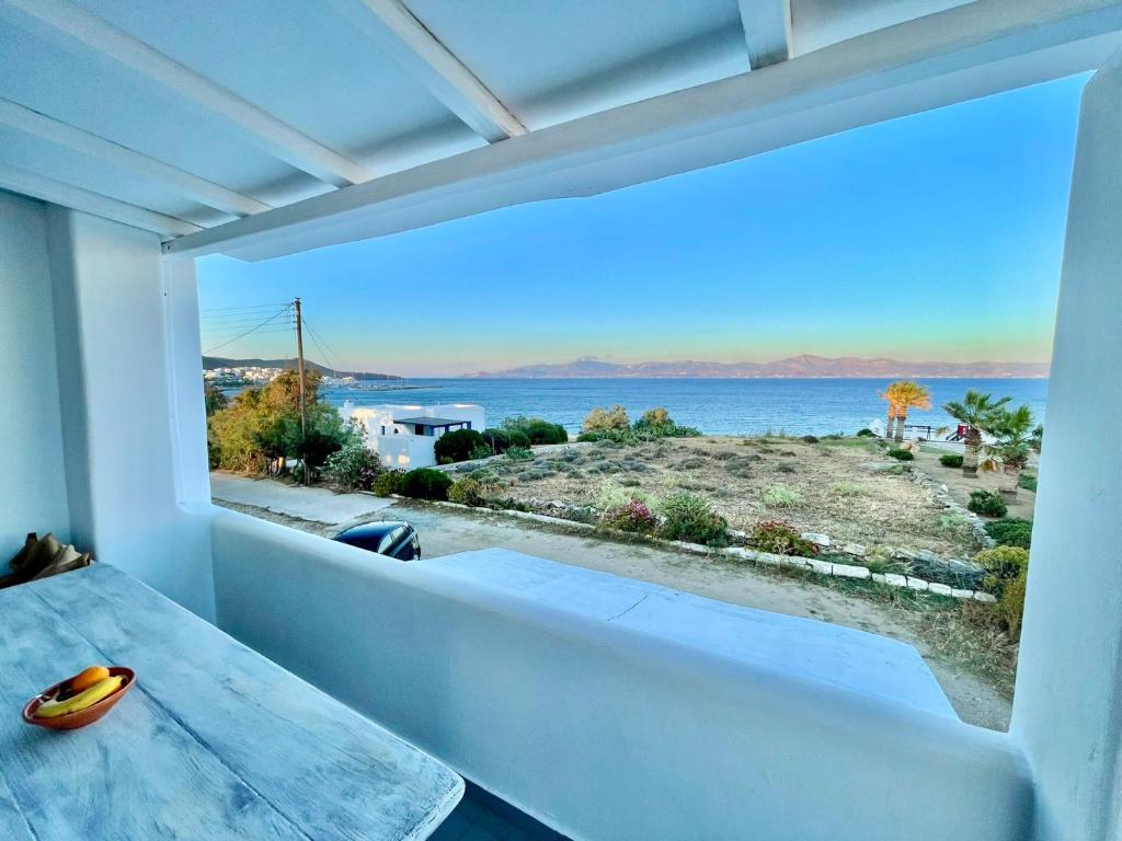 a room with a table and a view of the water at White Wave in Logaras