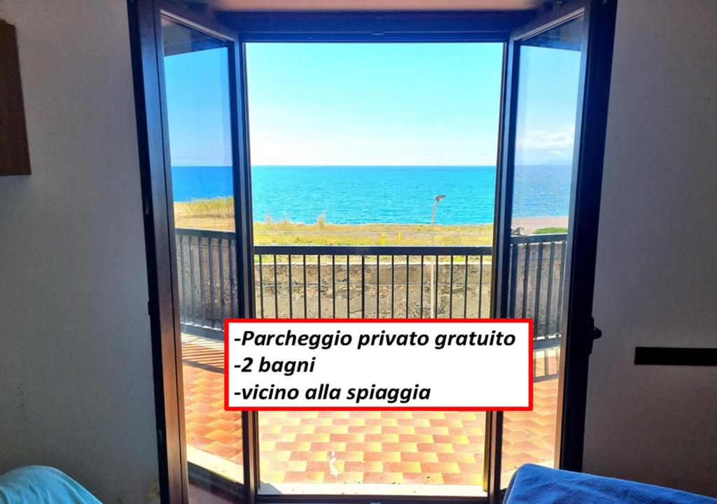 eine Tür zu einem Balkon mit Meerblick in der Unterkunft ROSSO - PROPPRO SRL - MILAZZO ISOLE EOLIEe in Milazzo
