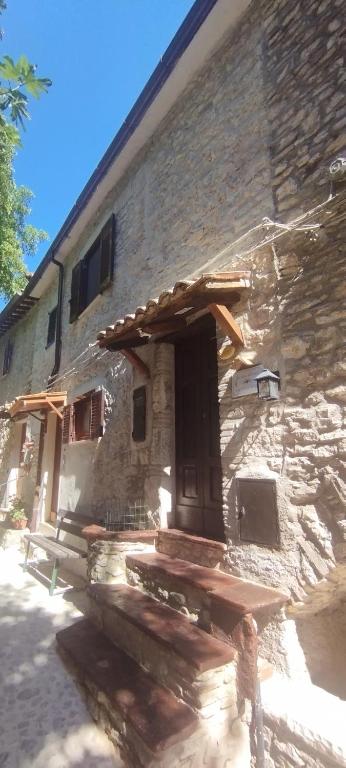 a stone building with a door and steps in front at Cottanello,"La casa del sole" in Cottanello