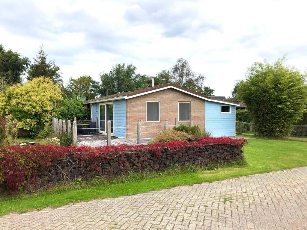 a small house in a yard with a fence at Vakantiehuis Nynke in Grou