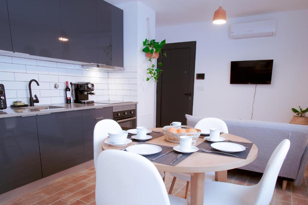 a kitchen with a wooden table and white chairs at Mar-Ria 2 in Fuzeta