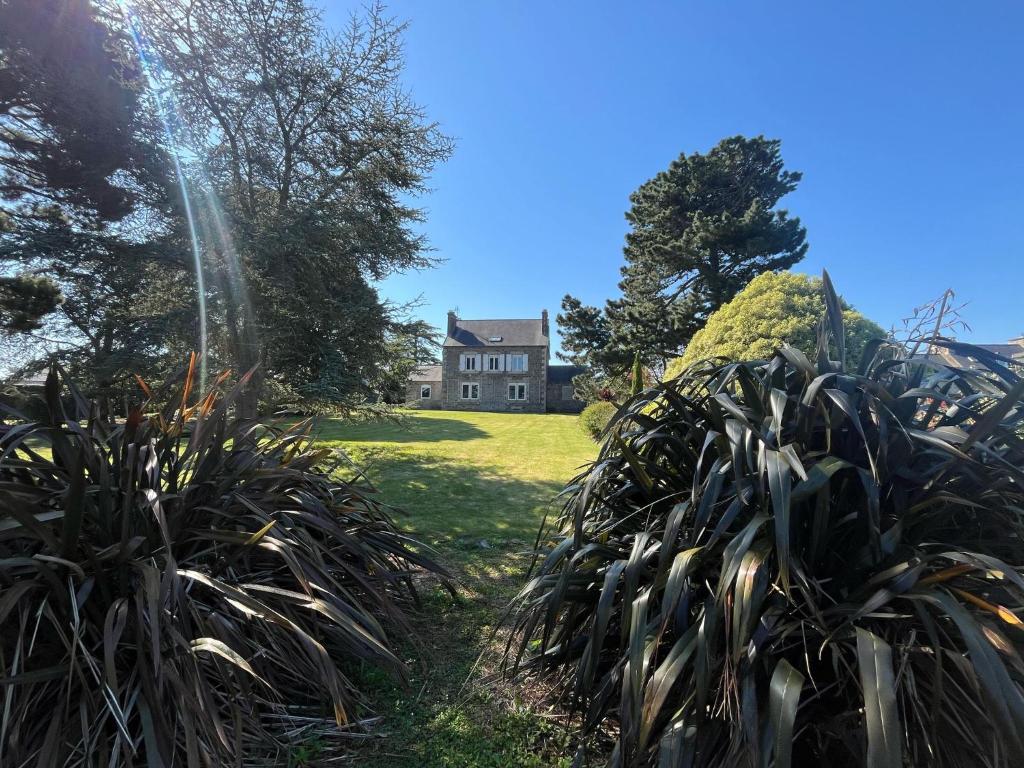 a house in the background with plants in the foreground at La Périgode - Magnifique demeure près des plages in Binic-Etables-sur-Mer