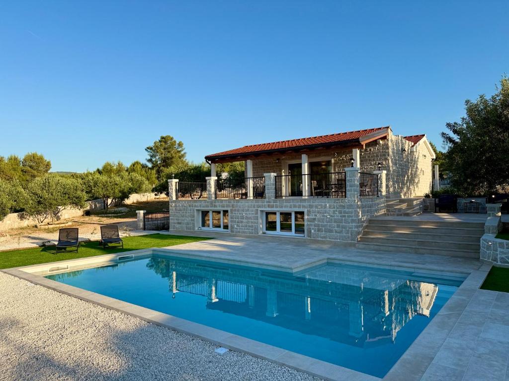a house with a swimming pool in front of a house at Villa Maginja in Sutivan