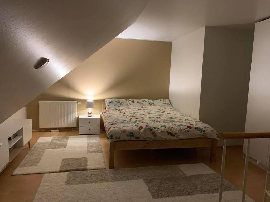 a small bedroom with a bed and a night stand at Pargi katusekorter in Kuressaare