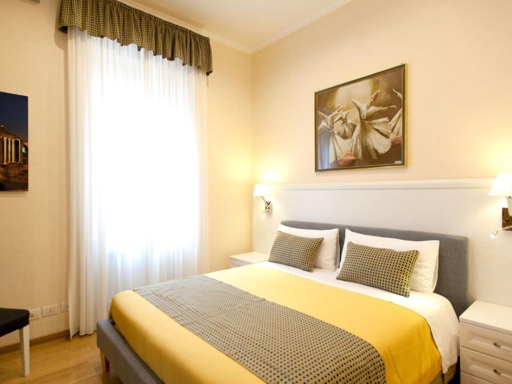 a bedroom with a bed with a yellow blanket and a window at New Apartment Sistina Trevi-Spagna in Rome