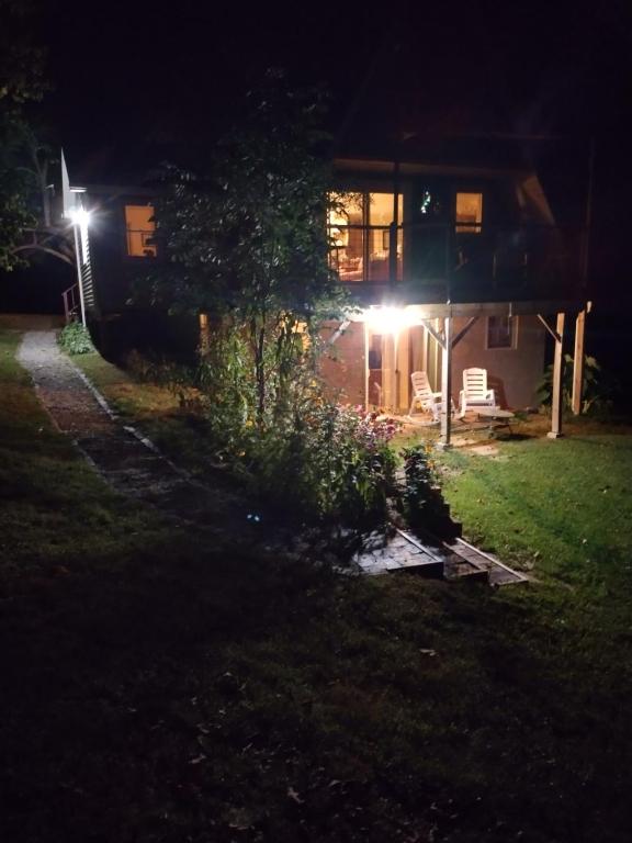 une maison éclairée la nuit dans la cour dans l'établissement Country suite with bath and laundry, à Athens