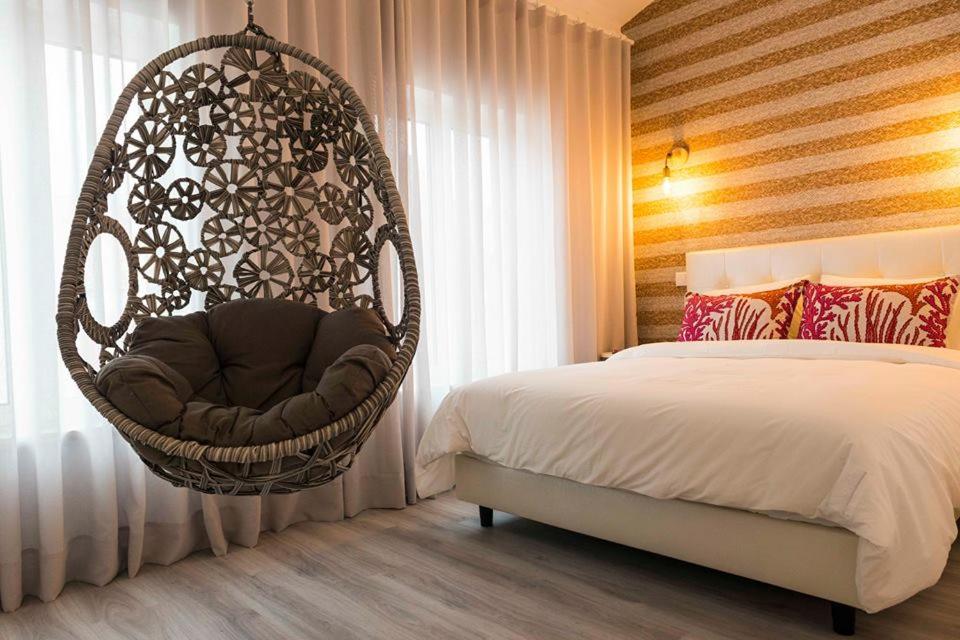 a bedroom with a hanging chair next to a bed at Home Sweet Praia in Nazaré