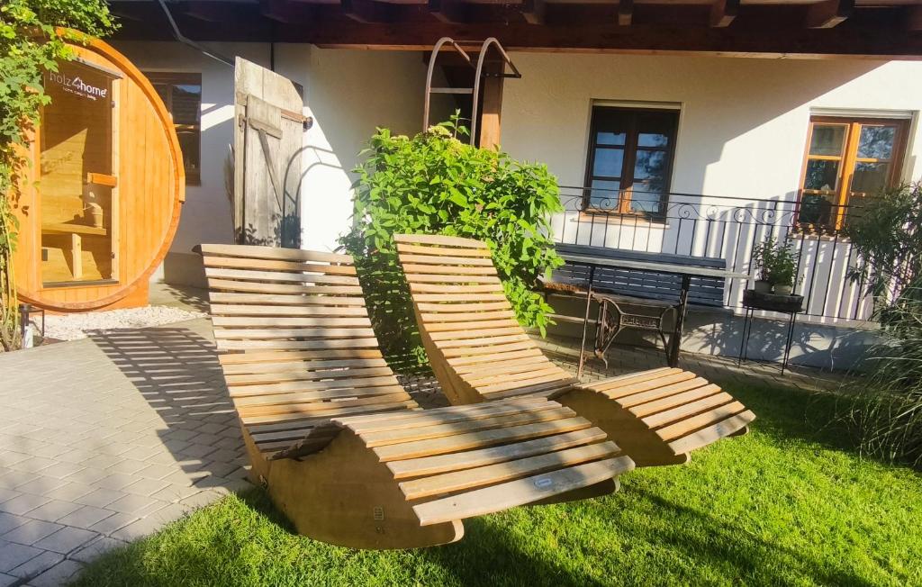 a wooden bench sitting in the grass in front of a house at Ferienwohnung Jahnel in Waging am See