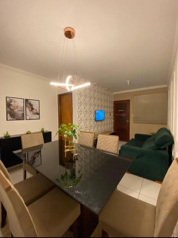 a living room with a table and a green couch at Casa Completa SJ - 6KM in Campina Grande