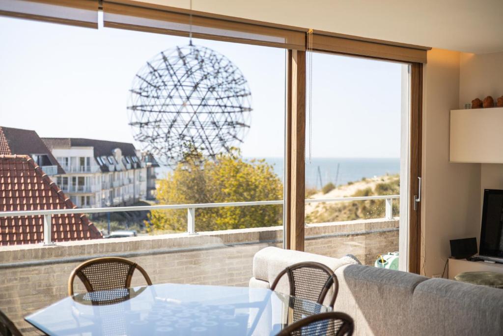 a table and chairs on a balcony with a view of the ocean at Shangri-La 0202 G in Sint-Idesbald