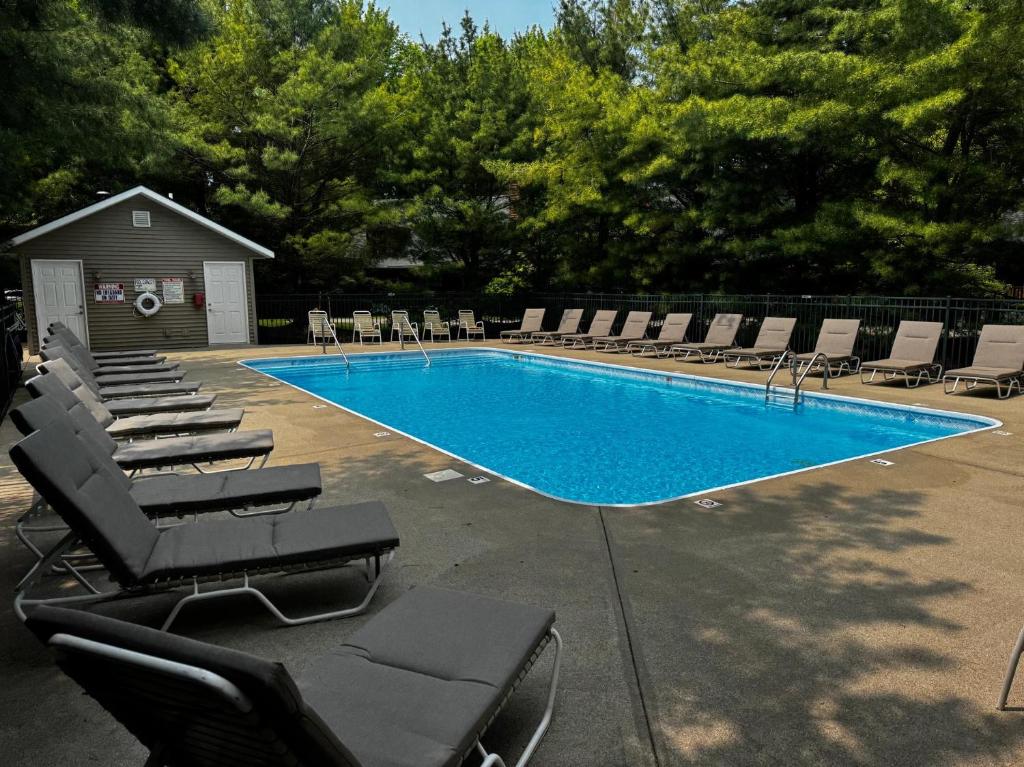 - une piscine avec des chaises longues et des chaises dans l'établissement Lilypad Dock on Goshorn Lake Pooltown, à Saugatuck