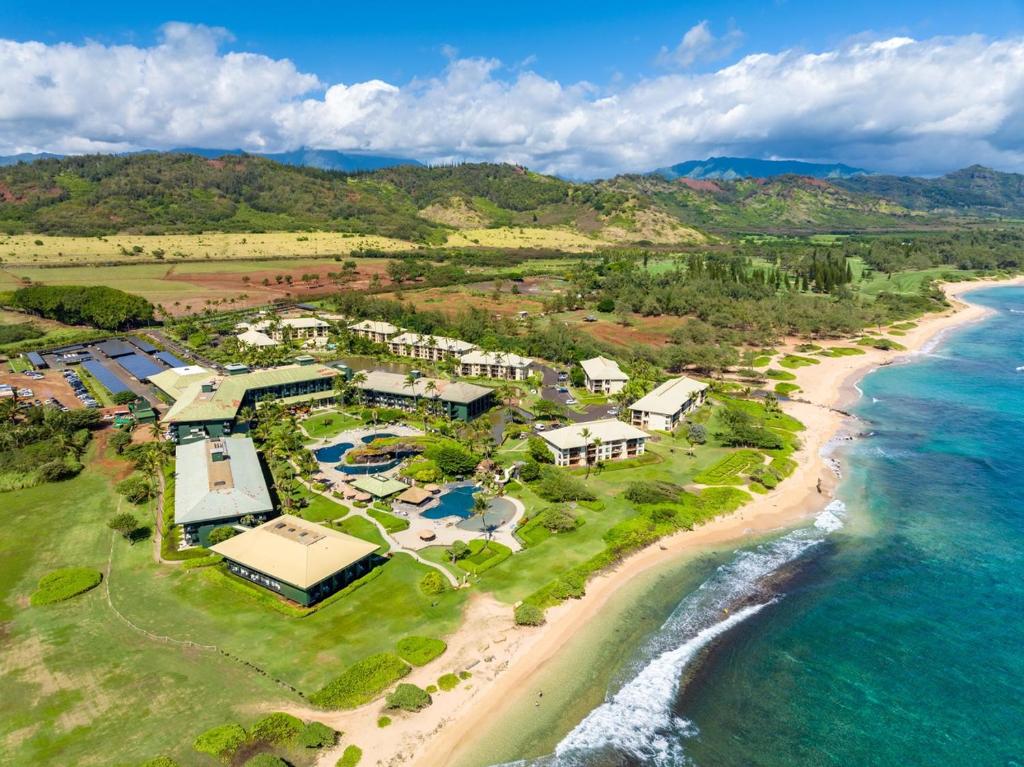 une vue aérienne d'un complexe hôtelier sur la plage dans l'établissement Pool Garden Lanai, Beachfront 4-Star Resort, King Bed, AC, Pool, Restaurant, Gym, Spa, à Lihue