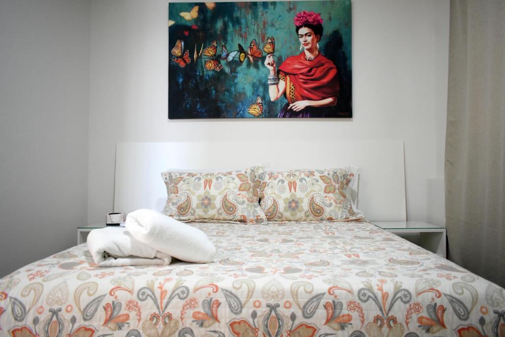 ein Schlafzimmer mit einem Bett und einem Gemälde an der Wand in der Unterkunft A - Céntrico Apartamento Privado - Alegría Housing in Aguascalientes