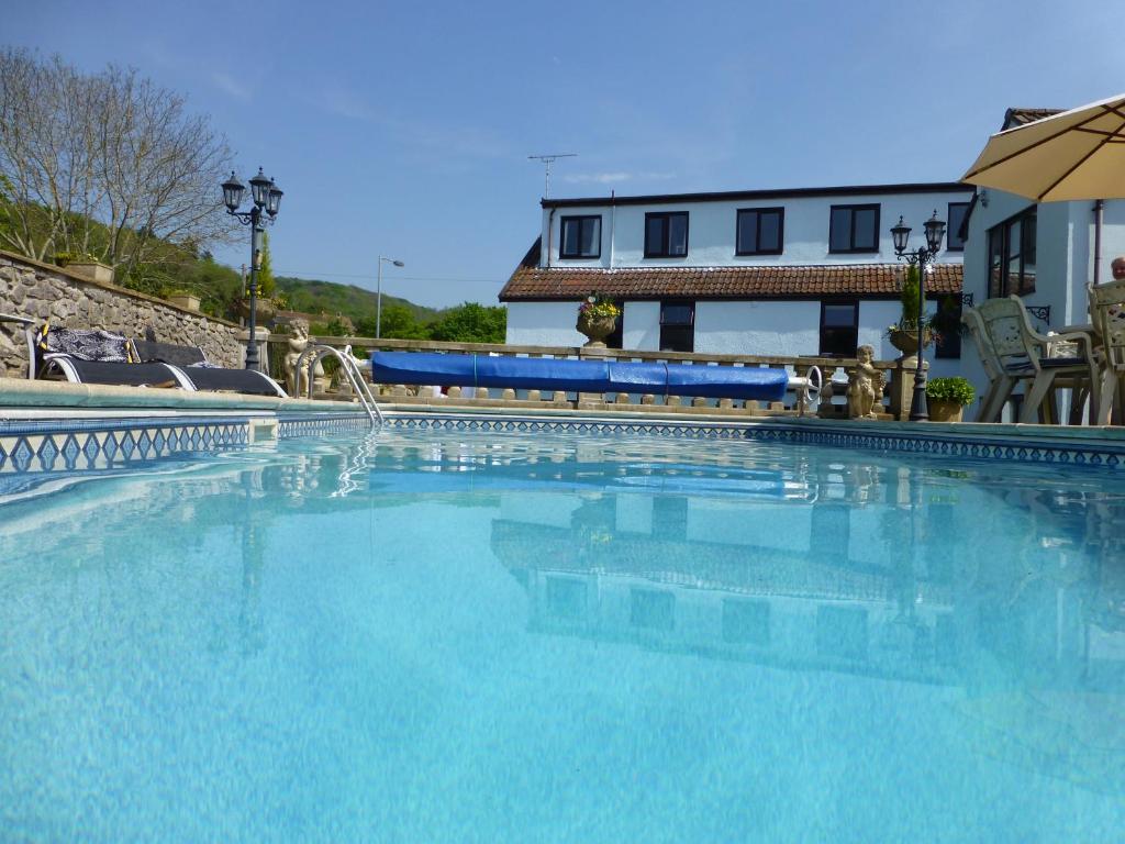 a large swimming pool with blue water in front of a building at Gordons in Cheddar