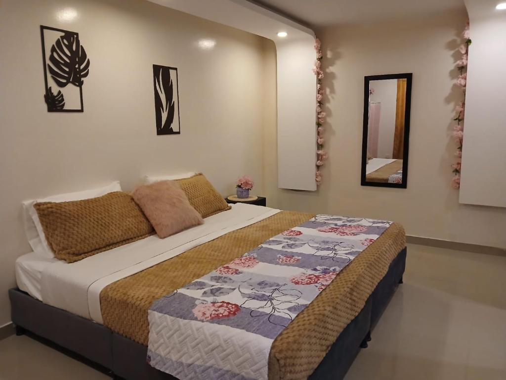 a bedroom with a bed with a quilt on it at Yashira Boutique Hotel in Bogotá