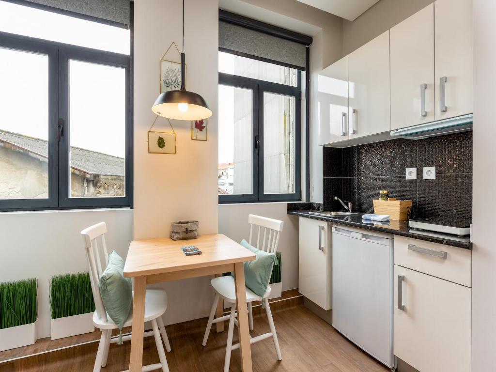 a small kitchen with a wooden table and chairs at Feel Porto Wine Essence II in Vila Nova de Gaia