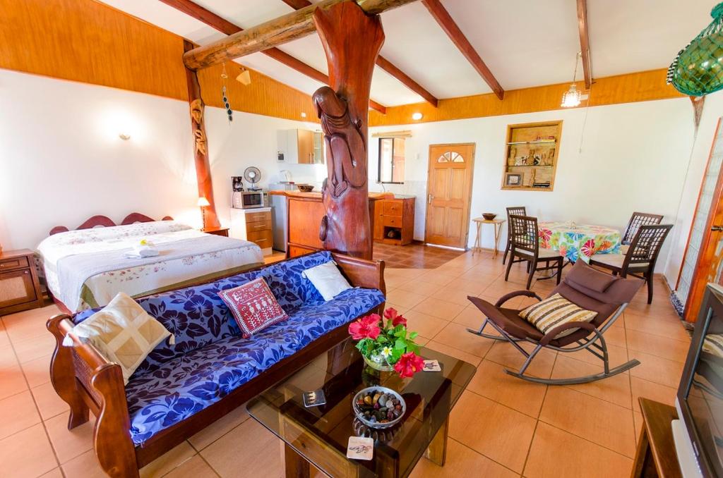 ein Wohnzimmer mit einem Bett und einem Sofa in der Unterkunft Cabañas Moai in Hanga Roa