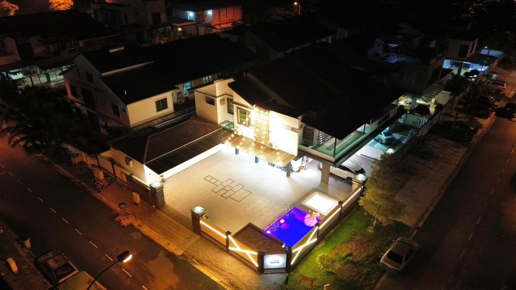 スクダイにあるHappinezzMo Homestayの夜間のプール付きの家の空中ビュー