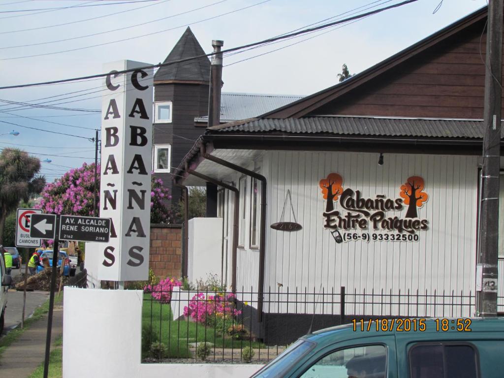 a car parked in front of a building with a sign at Cabañas Entre Parques in Osorno