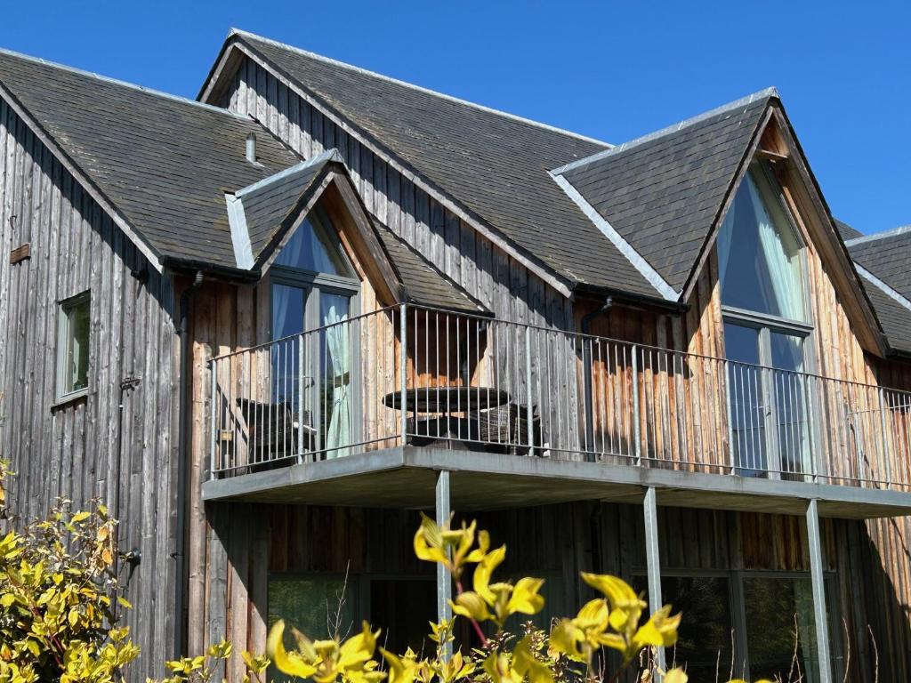 a house with a balcony with a dog on it at 6, The Gallops, Mains of Taymouth Estate, Kenmore in Kenmore